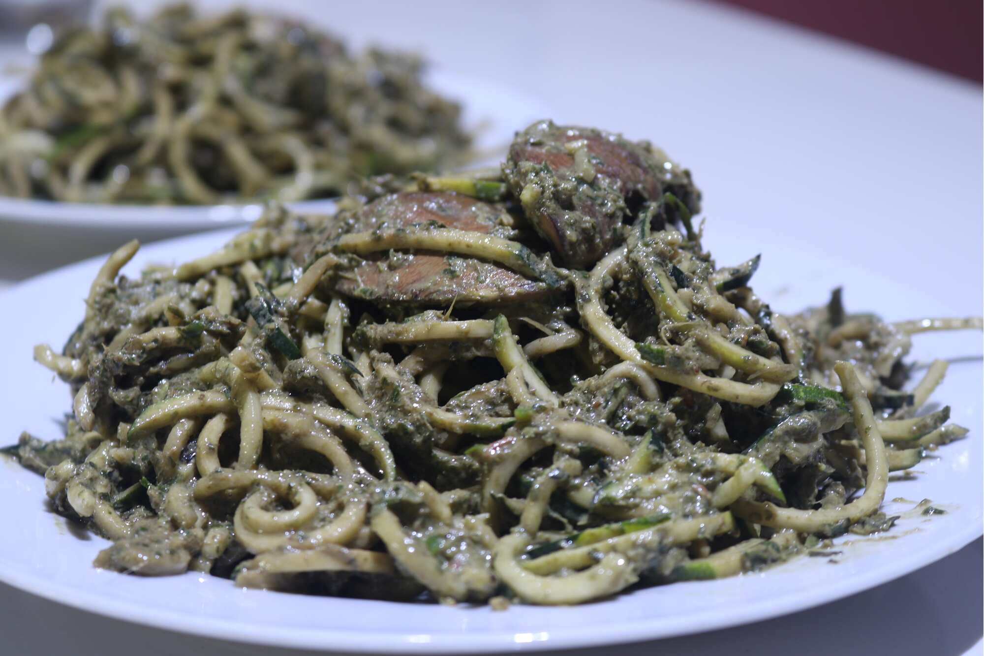 Zuchini Noodles with Basil Pesto topped with Portobelo Mushroom