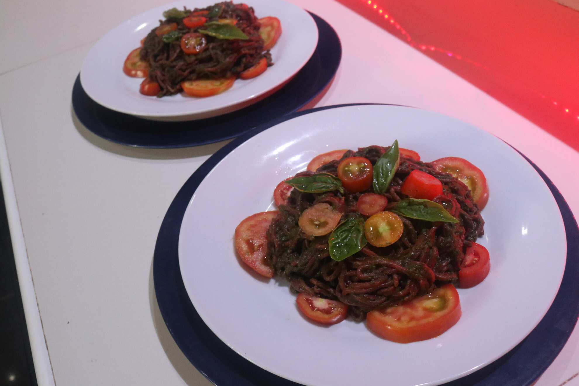 Beet-Wheat homemade Spaghetti noodles topped with Basil Pesto, fresh tomatoes and fresh basil